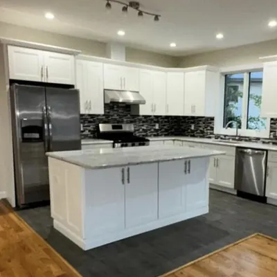 Cocina remodelada con isla y gabinetes blancos